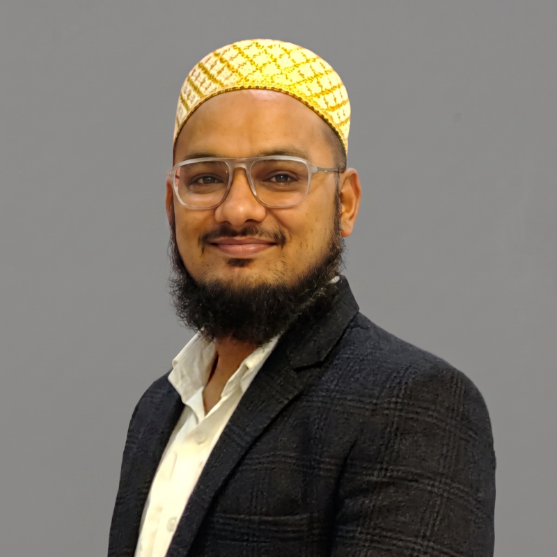 `Bluechip India team member in blazer and kufi cap smiling for professional headshot`